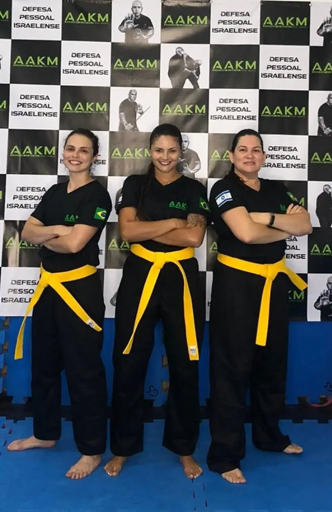 Alunas graduadas com faixa amarela no método AAKM de Krav Maga Feminino em Porto Alegre, ao lado do Mestre Adriano Almeida.